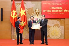 National Assembly Chairman Tran Thanh Man presents a 30-year Party membership badge to Vu Hai Ha, member of the Party Central Committee, Deputy Secretary of the NA Party Committee, Secretary of the Party Committee of advisory and support agencies of the NA Party Committee, and member of the NA Standing Committee, at a ceremony on July 9. (Photo: VNA)