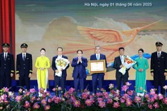 Prime Minister Pham Minh Chinh awards a certificate of merit to Vietnam Airlines. (Photo: VNA)