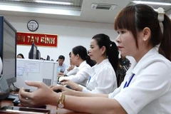 Civil servants of the newly established Tan Binh ward, HCM City, take part in a pilot operation session on June 11. (Photo: laodong.vn)