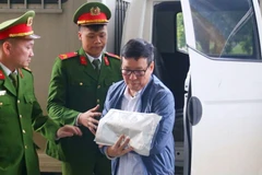 Le Duy Thanh, former Chairman of the Vinh Phuc People’s Committee, is escorted to the courtroom. (Photo: anninhthudo.vn)