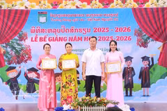 The school's board of management receives a certificate of merit from the Vientiane Capital Association of Vietnamese People. (Photo: VNA) 
