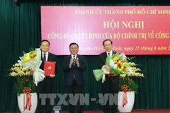 Standing member of the Party Central Committee’s Secretariat Tran Cam Tu (C) presents the Politburo’s decisions to Nguyen Van Nen (R) and Tran Luu Quang. (Photo: VNA)