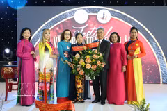 Ambassador Nguyen Dac Thanh presents flowers to President of the Vietnamese Businesswomen Association in Europe Trinh Thi Mui. (Photo: VNA) 