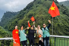 Foreign tourists in a photo with local residents. (Photo: VNA)
