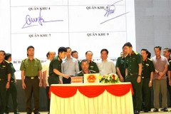 Representatives of ministries, agencies, and 21 coastal provinces and cities sign an agreement to carry out a peak emulation campaign against IUU fishing. (Photo: VNA) 