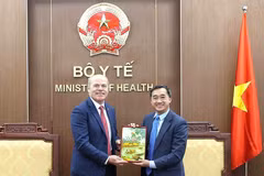 Deputy Minister of Health Tran Van Thuan (right) presents a souvenir to Canadian Ambassador to Vietnam James Nickel at the meeting on March 13. (Photo: T.M)