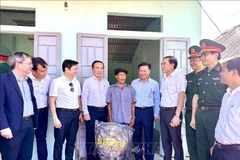 Members of the Steering Committee for the Elimination of Temporary and Dilapidated Houses in Quang Tri province visit and present gifts to a poor household in Huong Hoa district who received support to build a new house. (Photo: VNA)