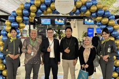 The Vietnam Airlines representative in Indonesia (third from left) in a group photo with passengers of the first flight on the Jakarta-Hanoi route at Soekarno–Hatta International Airport, Indonesia. (Photo: VNA)