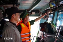 A border guard officer of Dong Thap examines the operation of the vessel monitoring system on a fishing boat. (Photo: VNA)