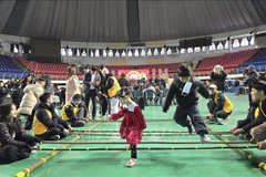 Mua sap (bamboo dancing), a traditional Vietnamese folk game, attracts many children from multicultural families to take part. (Photo: VNA)