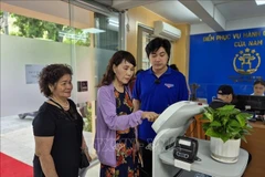 Citizens use AI-powered robot at the Cua Nam ward public service centre. (Photo: VNA)