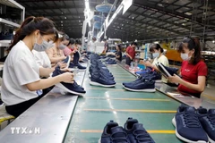 Workers produce footwear for export. (Photo: VNA)