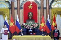 Then State President To Lam (second from right) and Russian President Vladimir Putin witness the exchange of signed documents between the two countries following their talks in Hanoi on June 20, 2024. (Photo: VNA)