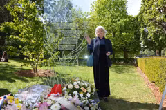 Tran To Nga poses for a photo beside the memorial plaque dedicated to Agent Orange/dioxin victims at Choisy Park in Paris (Photo: VNA) 