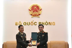 Minister of National Defence Gen. Phan Van Giang (R) hands over a gift to Secretary of State at the Cambodian Ministry of National Defence Gen. Prum Din at their meeting in Hanoi on March 9 (Photo: qdnd.vn)