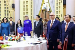 State President Luong Cuong, his spouse, together with Australian Governor-General Sam Mostyn and her spouse and delegates take part in a flag-saluting ceremony at the banquet. (Photo: VNA)