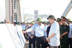 Party General Secretary To Lam listens to a leader of Thai Nguyen province report on flood and storm recovery work at Ben Tuong bridge. (Photo: VNA)