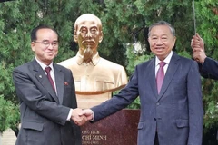 General Secretary of the Communist Party of Vietnam Central Committee To Lam (R) and Jo Yong Won, member of the Presidium of the Political Bureau, Secretary of the Central Committee, and head of the Organisation and Guidance Department of the WPK, shake hands in front of the statue. (Photo: VNA)