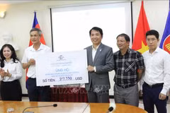 A representative of the Vietnam–Cambodia Business Association (VCBA) presents its donated fund to the leaders of the Vietnamese Ambassador to Cambodia Nguyen Minh Vu (2nd from left). (Photo: VNA)