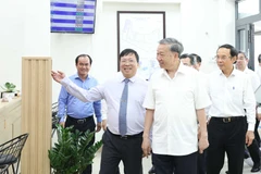 Party General Secretary To Lam (C) visits the Public Administrative Service Centre in Tan Vinh Loc commune, Ho Chi Minh City. (Photo: VNA) 