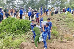 Hundreds of people from the military, police, coast guard, and local people in Ha Tinh province are mobilised to reinforce the Hoi Thong dike before the Typhoon Kajiki. (Photo: VNA)