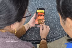 Residents are watching a short animated clip created using AI by the police in Bo Trach commune, Quang Tri province, to raise public awareness and provide warnings about crimes. (Photo: VNA) 