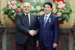 Vietnamese State President Luong Cuong (R) shakes hands with Russian Prime Minister Mikhail Mishustin. (Photo: VNA)