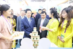 Deputy Prime Minister Mai Van Chinh visits a Vietnamese booth at the 22nd CAEXPO (Photo: VNA)