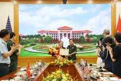 Deputy Defence Minister Senior Lieutenant General Hoang Xuan Chien (R) presents a certificate of merit from the Minister of National Defence of Vietnam to USAID's Mission Director for Vietnam Aler Grubbs (Photo: VNA)