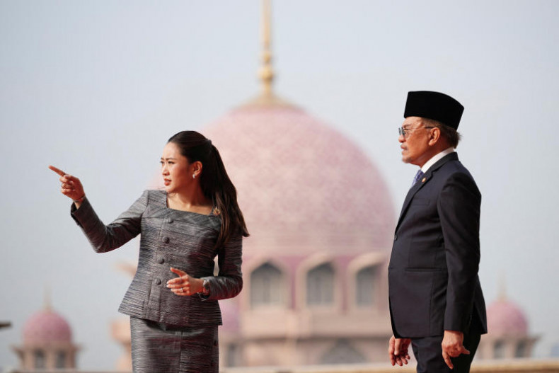 Thai Prime Minister Paetongtarn Shinawatra gestures as she talks with Malaysian Prime Minister Anwar Ibrahim with Putra Mosque in the background during a welcoming ceremony prior to their meeting in Putrajaya on Monday. (Photo: Pool via Reuters)