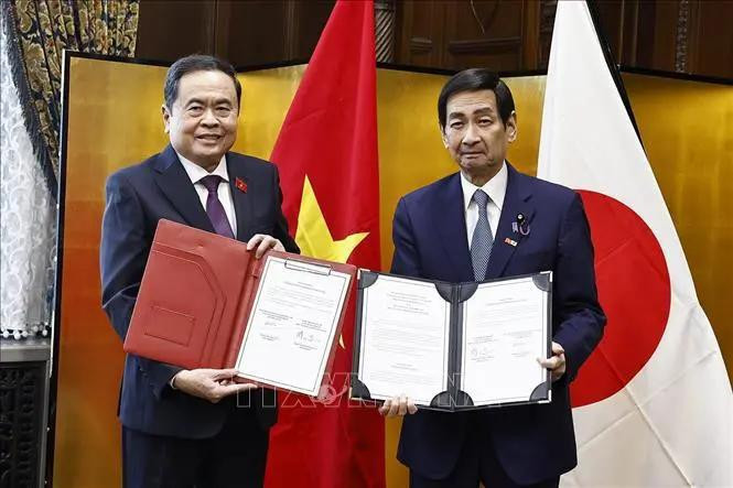 National Assembly Chairman Tran Thanh Man and President of the House of Councilors of Japan Sekiguchi Masakazu exchange cooperation documents. (Photo: VNA)
