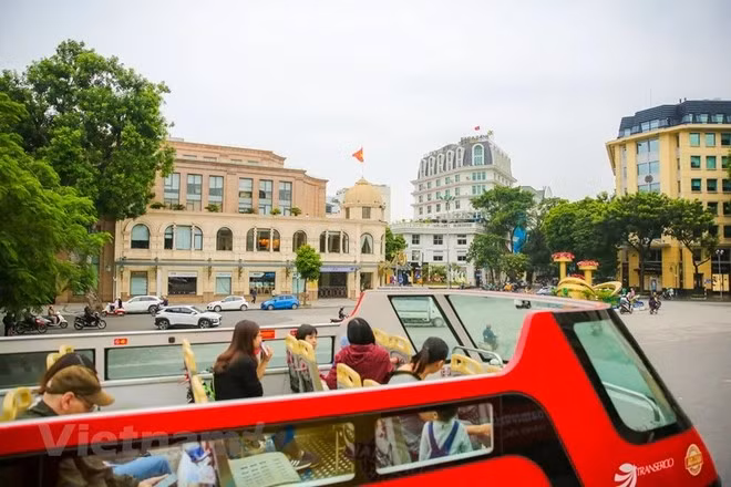 Tourists visit Hanoi by double-decker bus (Photo: VNA)
