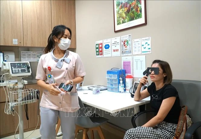 A person gets her eyes tested by a Sunway Medical Centre's staff. (Photo: VNA) 