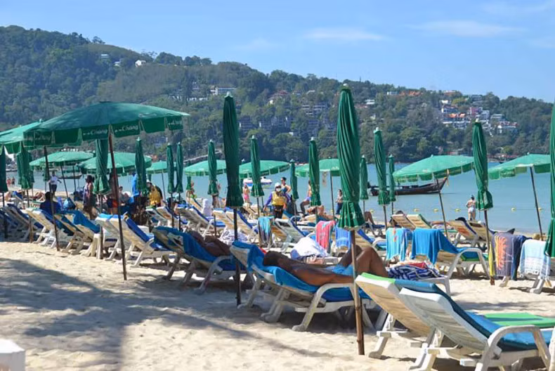 Tourists relax on a beach in Phuket (Photo