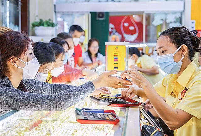 Customers purchase gold rings at a jewellery store. (Photo: cand.com.vn)