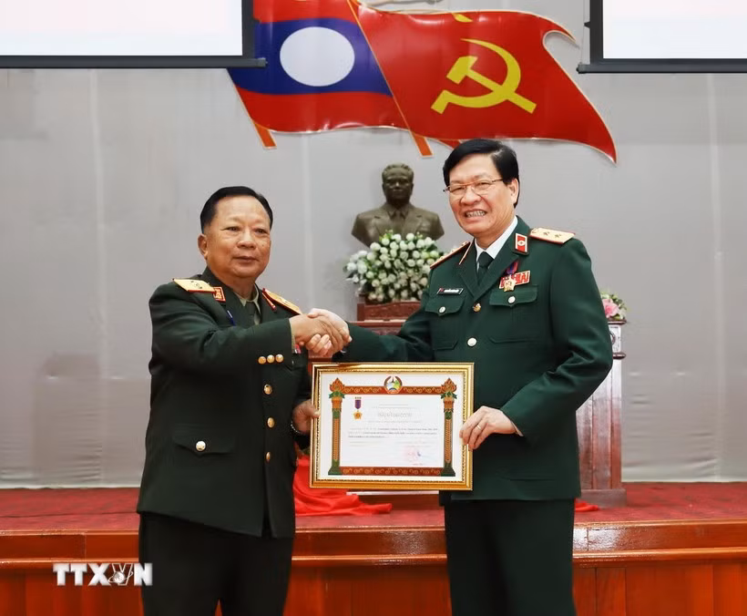 Lao Deputy Prime Minister and Minister of National Defence Gen. Chansamone Chanyalath presents a first-class Labour Order to VMMU Director Nguyen Xuan Kien. (Photo: VNA)