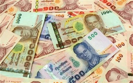Piles of Thai currency (Source:Telegraph.com)