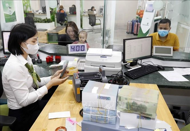 Customers make transactions at Vietcombank's branch in Vinh Phuc province. (Photo: VNA)