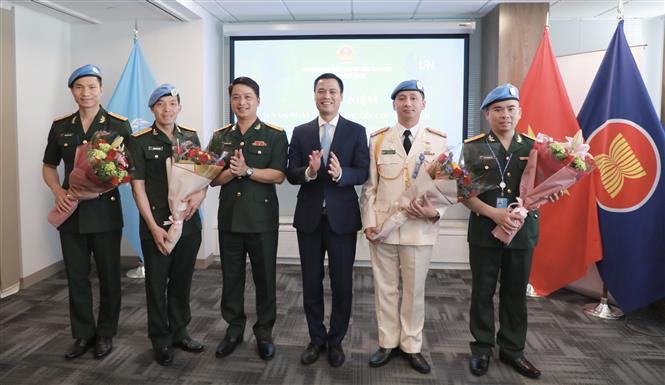 Ambassador Dang Hoang Giang (third from right) congratulates the military and public security officers working at the UN Department of Peace Operations at the ceremony in New York on May 24. (Photo: VNA)