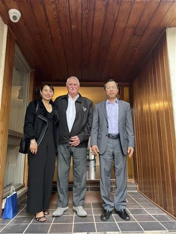 Vietnamese Ambassador to Australia Pham Hung Tam (R) and Australian veteran John Bryant (C) posing for a photo (Photo: VNA)