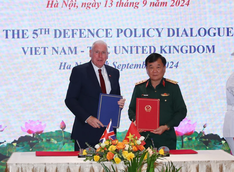 Sen. Lieut. Gen Hoang Xuan Chien and UK Minister of State for Defence Vernon Coaker sign minutes of the dialogue (Photo: VNA)