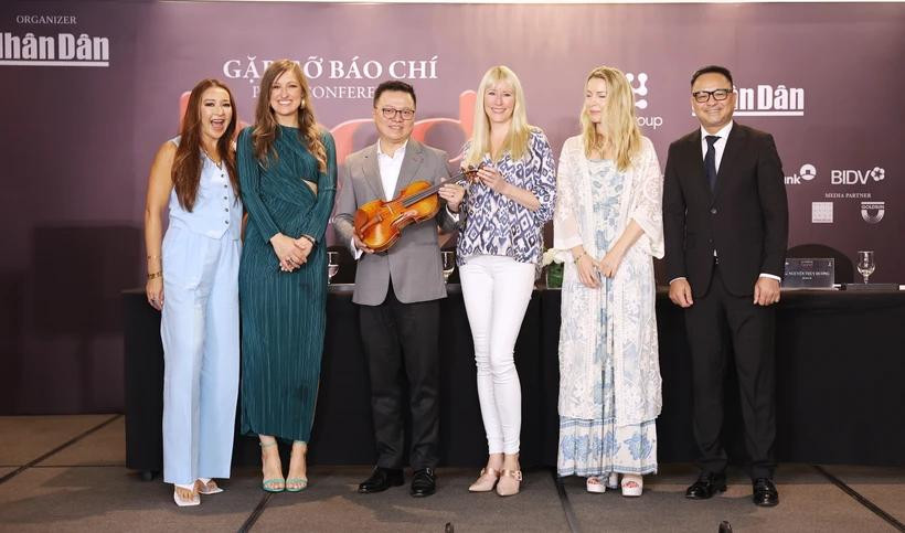 The BOND string quartet presents the concert organisers with a special gift – a violin signed by all four members. (Photo: VietnamPlus)