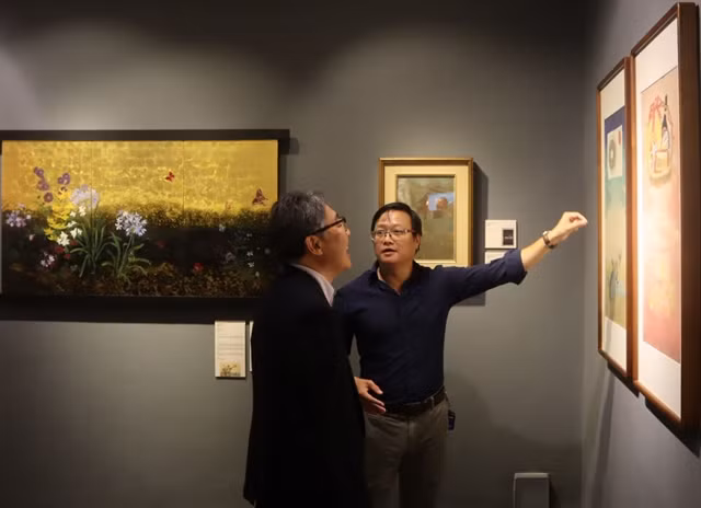 Exhibition curator Nguyen The Son introduces artworks at the exhibition. (Photo: vanhoanghethuat.vn)