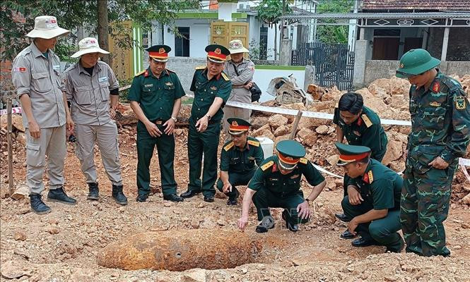Authorities inspect and devise a plan to safely dispose of the 334 kg bomb. (Photo: VNA)