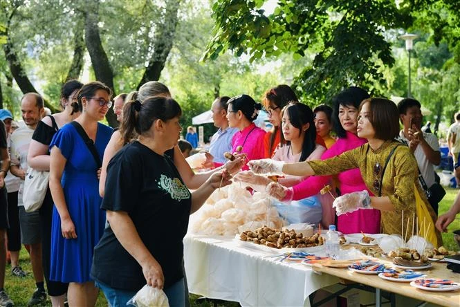 Visitors to the Vietnamese Culture Day event have some Vietnamese food. (Photo: VNA broadcasts)