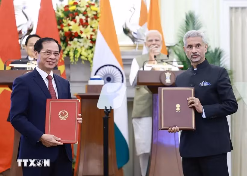 Leaders of the foreign ministries of Vietnam and India exchange an agreement between their governments allowing family members of diplomatic and consular staff to work for income. (Photo: VNA)