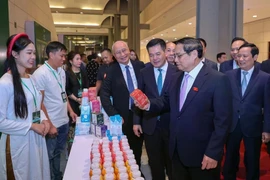 Prime Minister Pham Minh Chinh visits a booth of TH Group on the sidelines of the 9th announcement of products meeting national brand standards. (Photo: VietnamPlus)