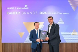Vietcombank Deputy General Director (left) Le Hoang Tung receives the "Top 30 Most Valuable Brands in Southeast Asia" certificate from Director of Strategic Development at Kantar Insights Sumit Kamra. (Photo: VietnamPlus)