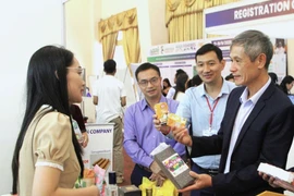 Vietnamese Ambassador to Cambodia Nguyen Minh Vu (R) visits a Vietnamese booth at the agricultural expo. (Photo: VNA)