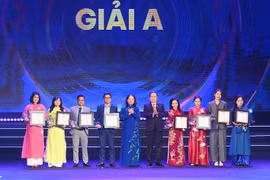 NA Chairman Tran Thanh Man (5th from right) and State Vice President Vo Thi Anh Xuan (5th from left) present the first prizes to excellent journalists. (Photo: VNA)